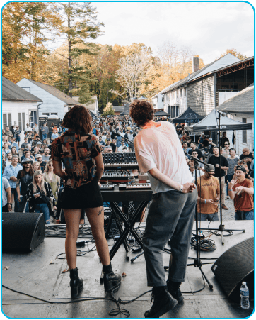 music performers on stage in front of large crowed