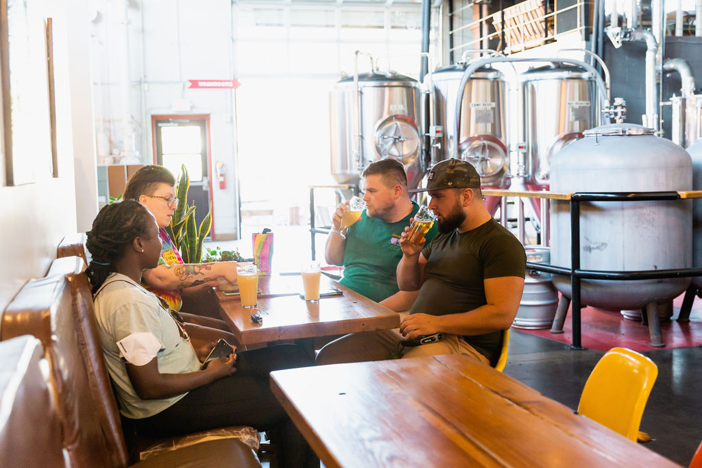 guests gather around a bar with beers