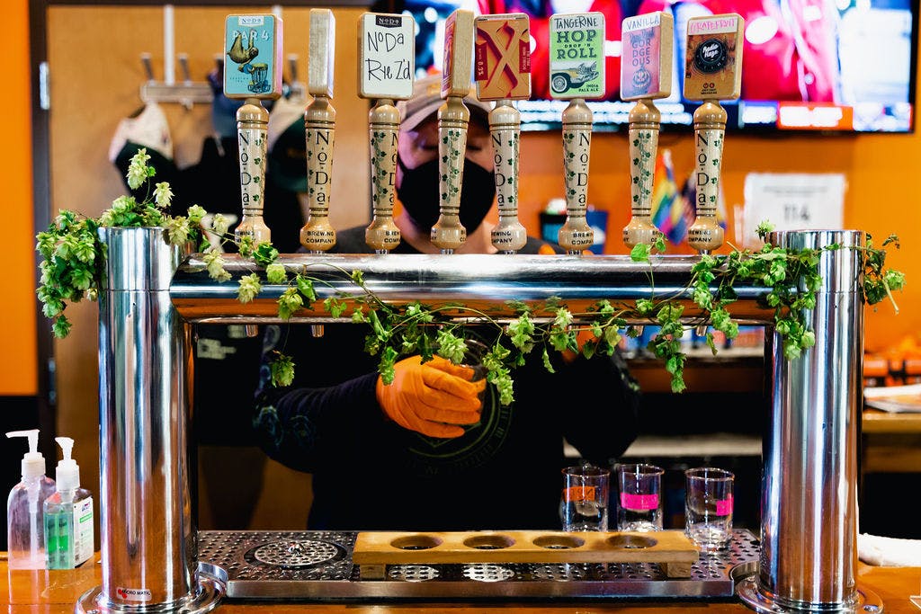 A row of tap handles wrapped in greenery