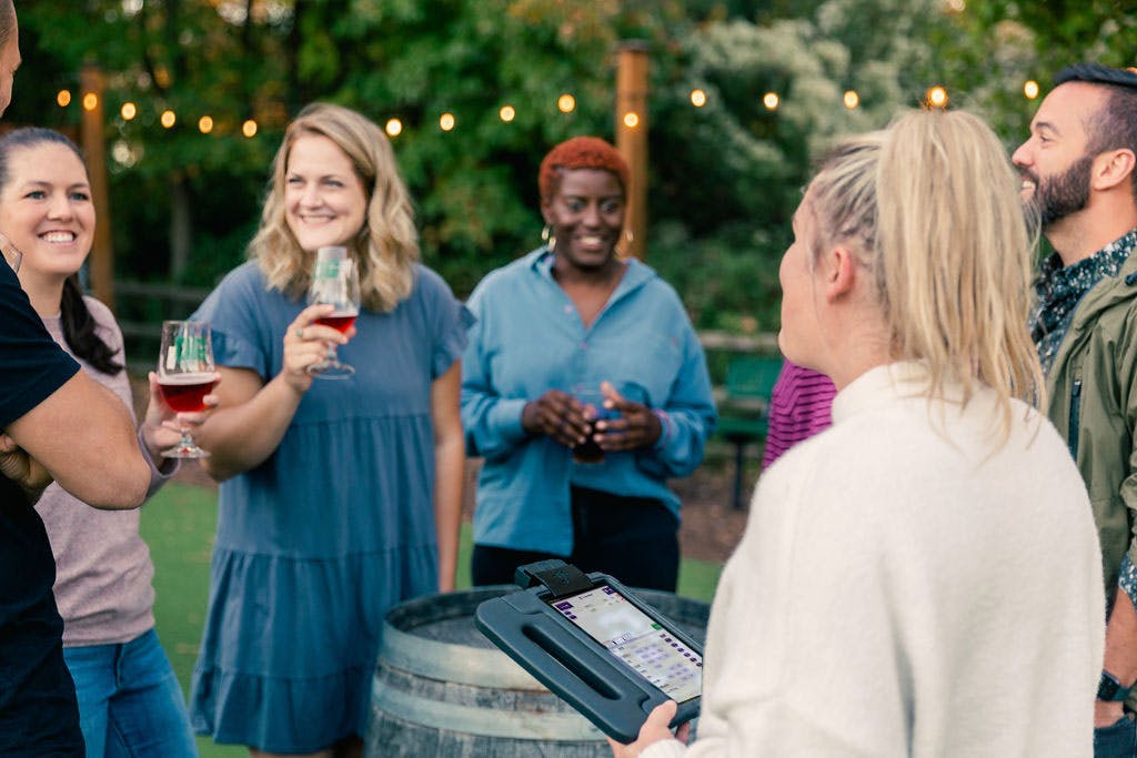 several people enjoy beers outside around a table