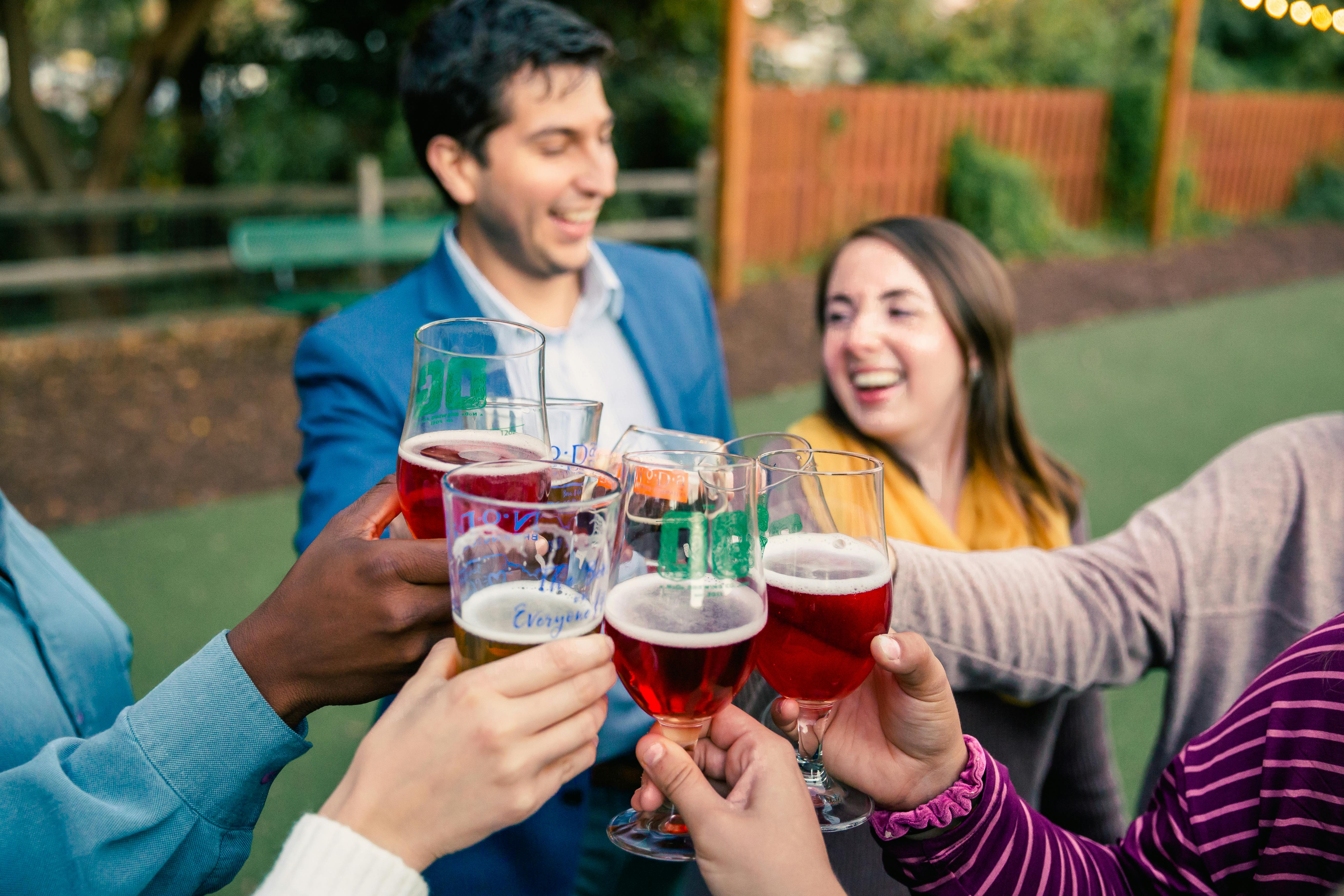 group of adults cheering with beer at party