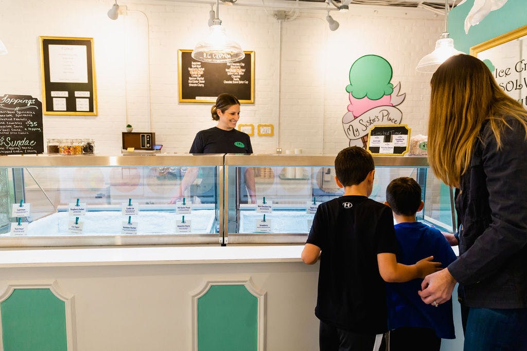 two kids look at case of ice cream to decide what to order
