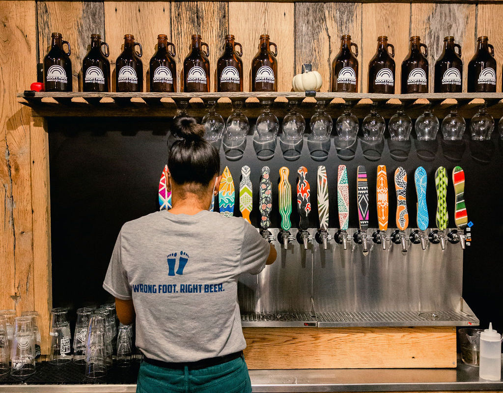 a bartender pours a beer from a tap