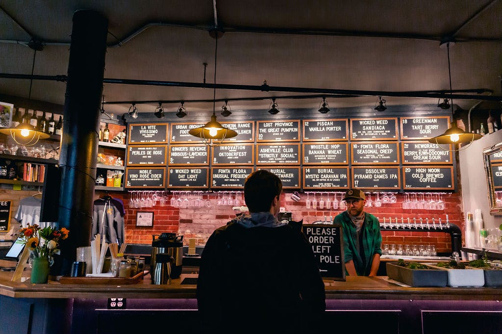 person standing in front of a bar at a taproom