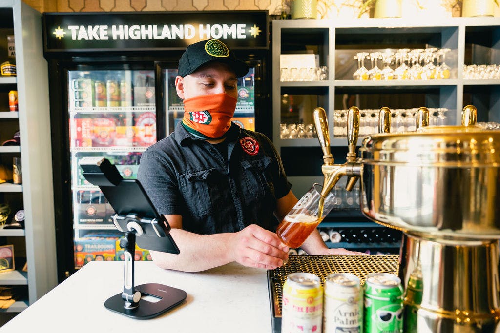 Bartender pours a beer from a tap