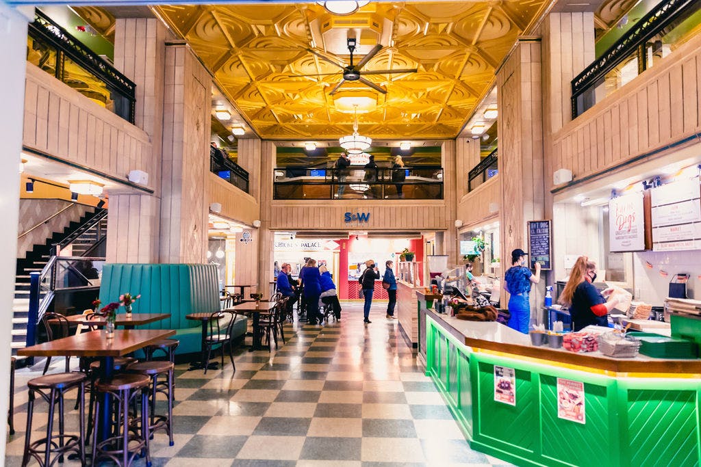 large, open room with tiles floors and a green bar