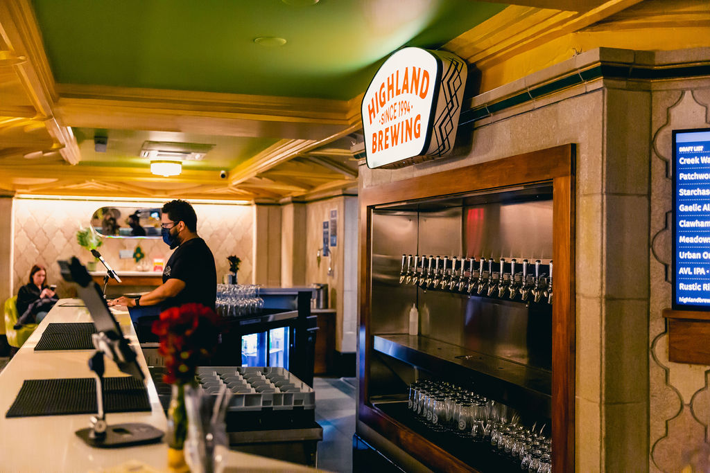 bartender serves beer behind a cozy bar