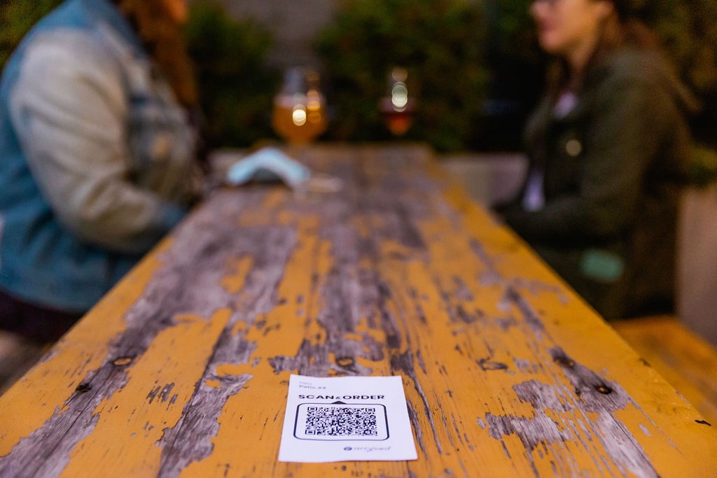 long wooden bar with a QR code for ordering beer