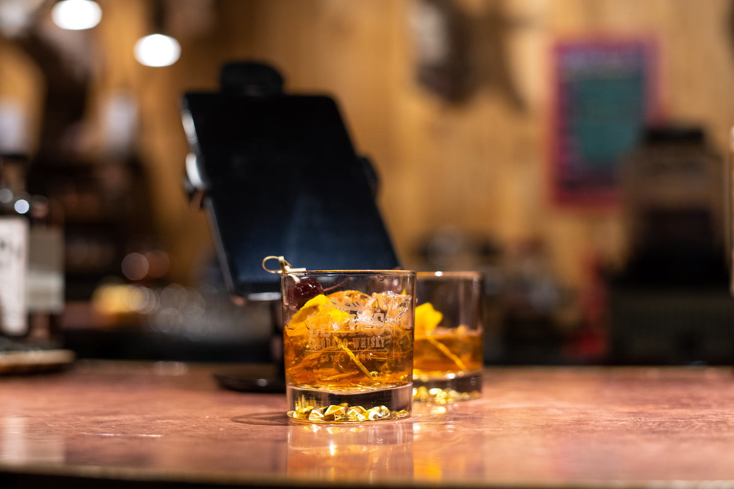 two cocktails in glasses on a wooden bar