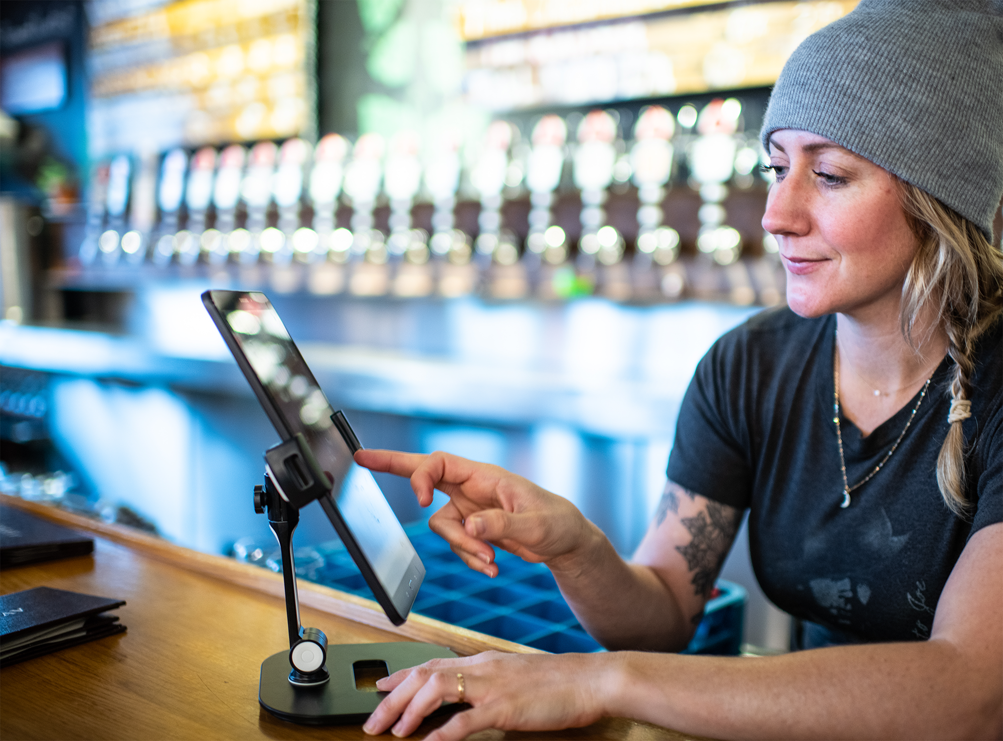 bartender uses Arryved POS on a tablet behind the bar
