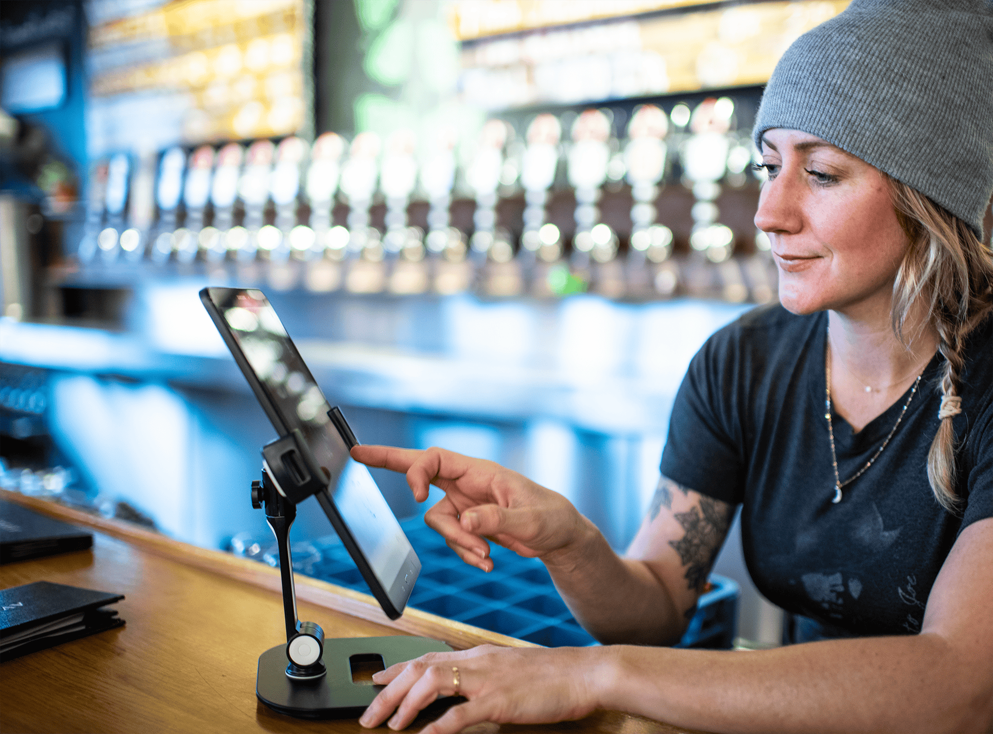 bartender uses Arryved POS on a tablet behind the bar