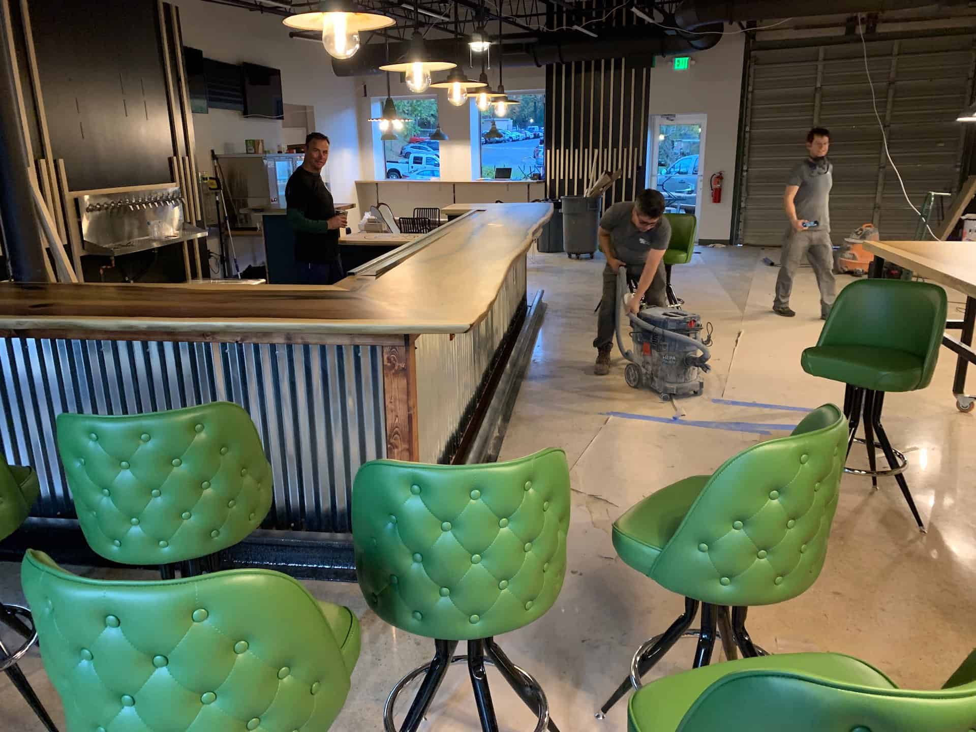 interior of Babycat taproom with green leather bar stools