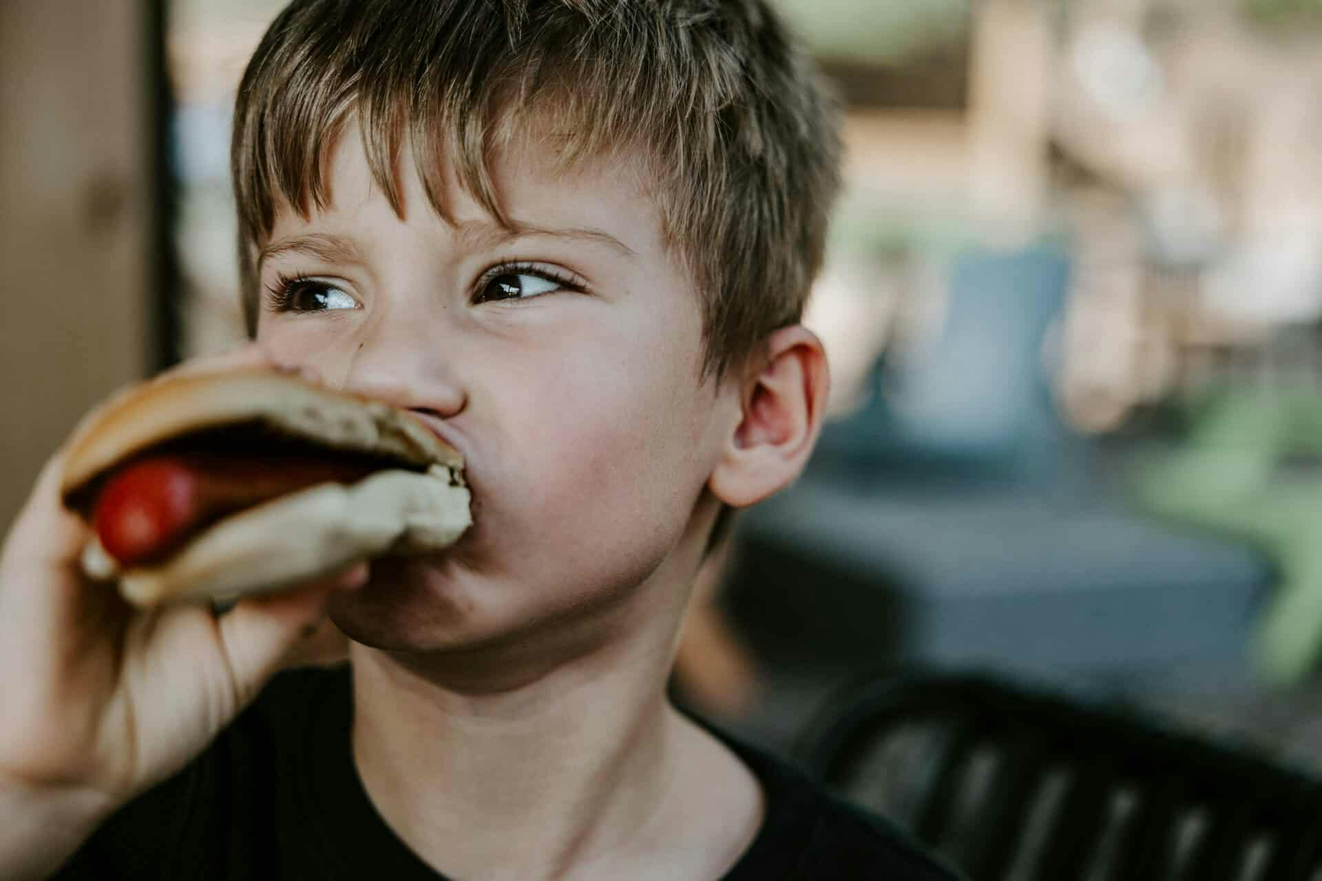 KSG25758 a young boy eats a hot dog