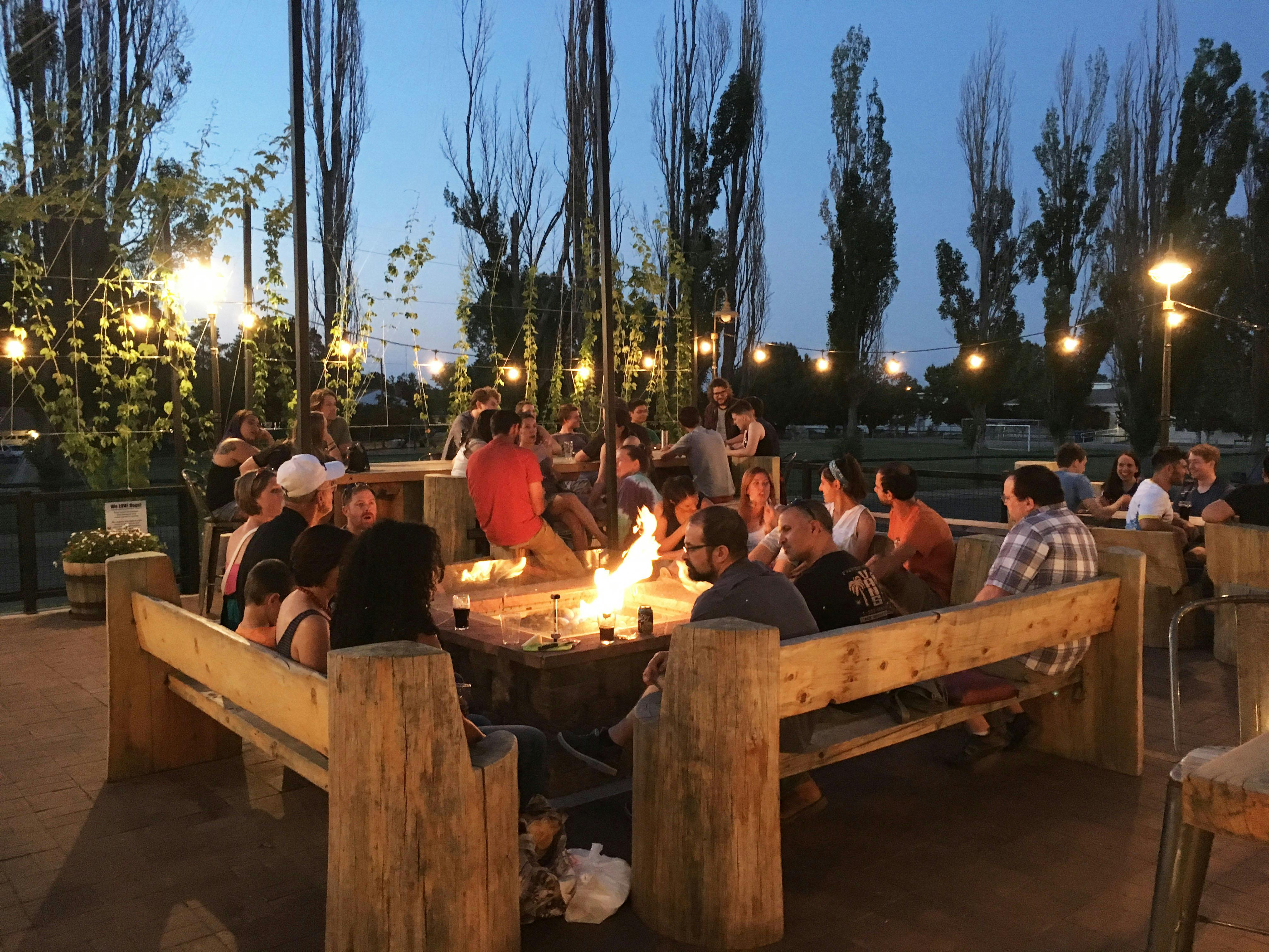 a cozy fire pit ouside on a patio with wooden benches