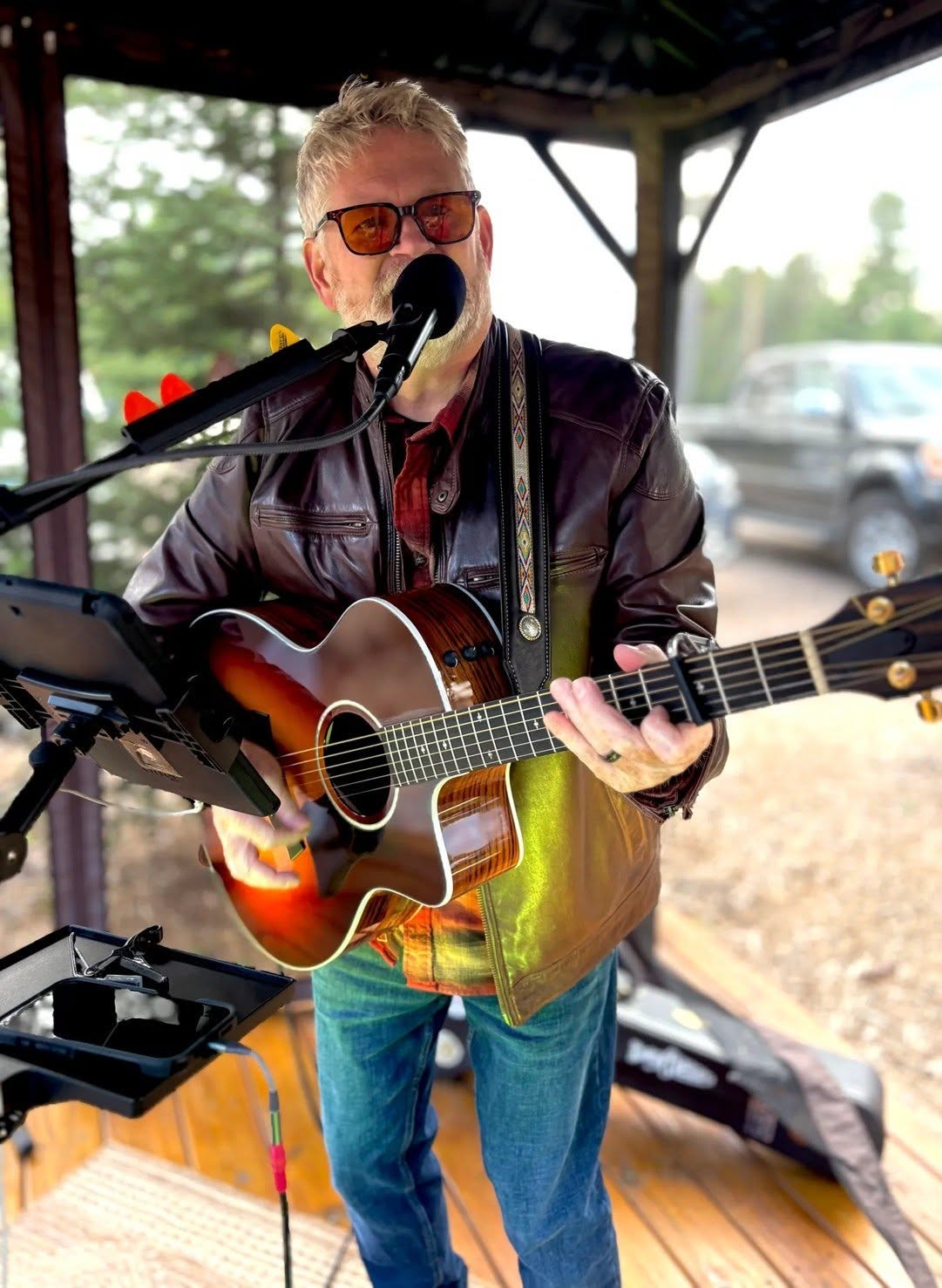 Man with a microphone and a guitar playing and singing outdoors