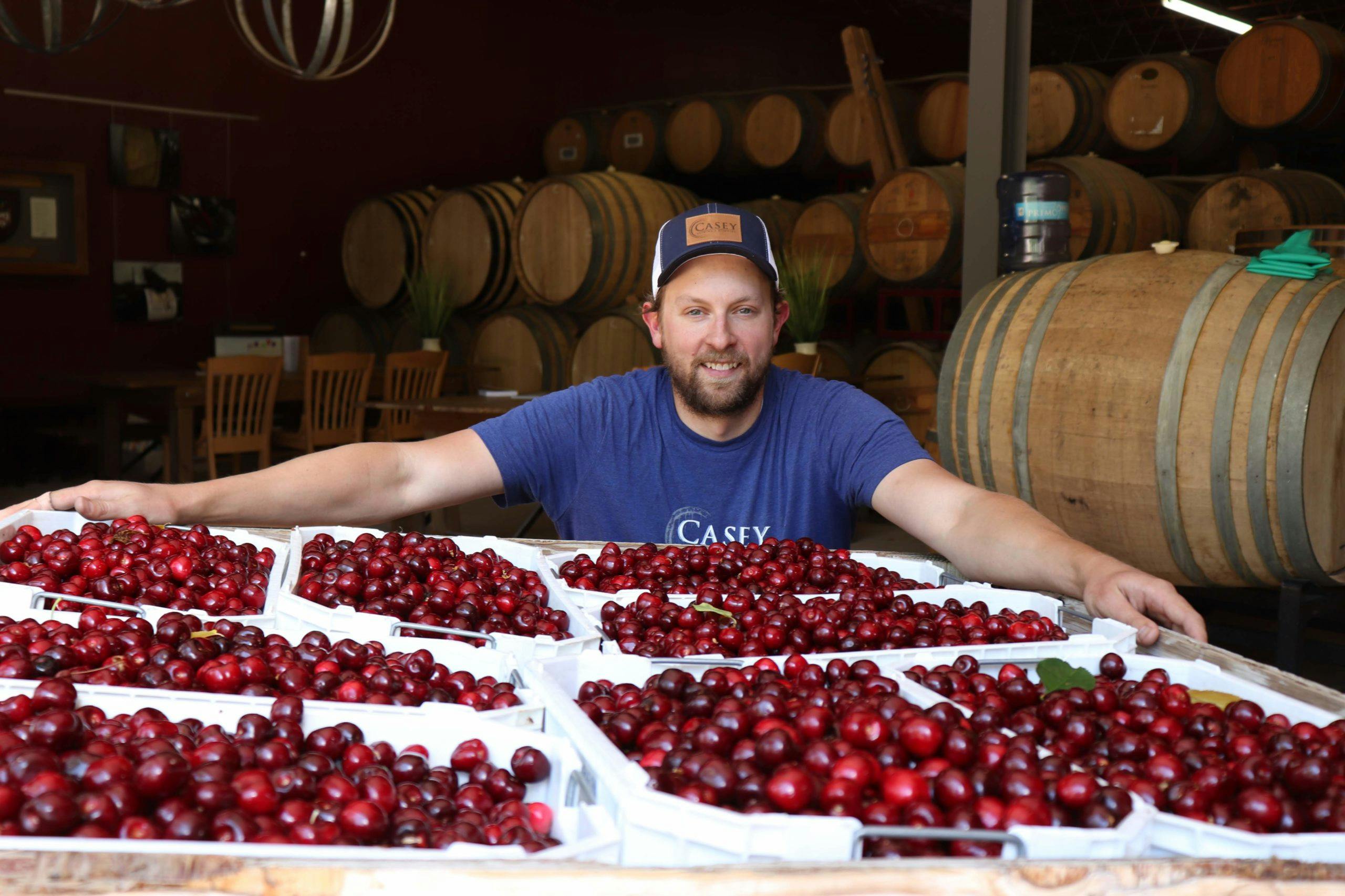 Troy Casey holding box of cherries for sour beer