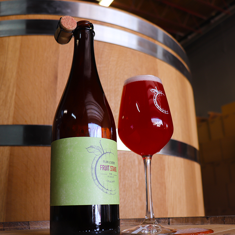 Casey Brewing and Blending's Plum and Cherry Fruit Stand on barrel in front of a Foeder