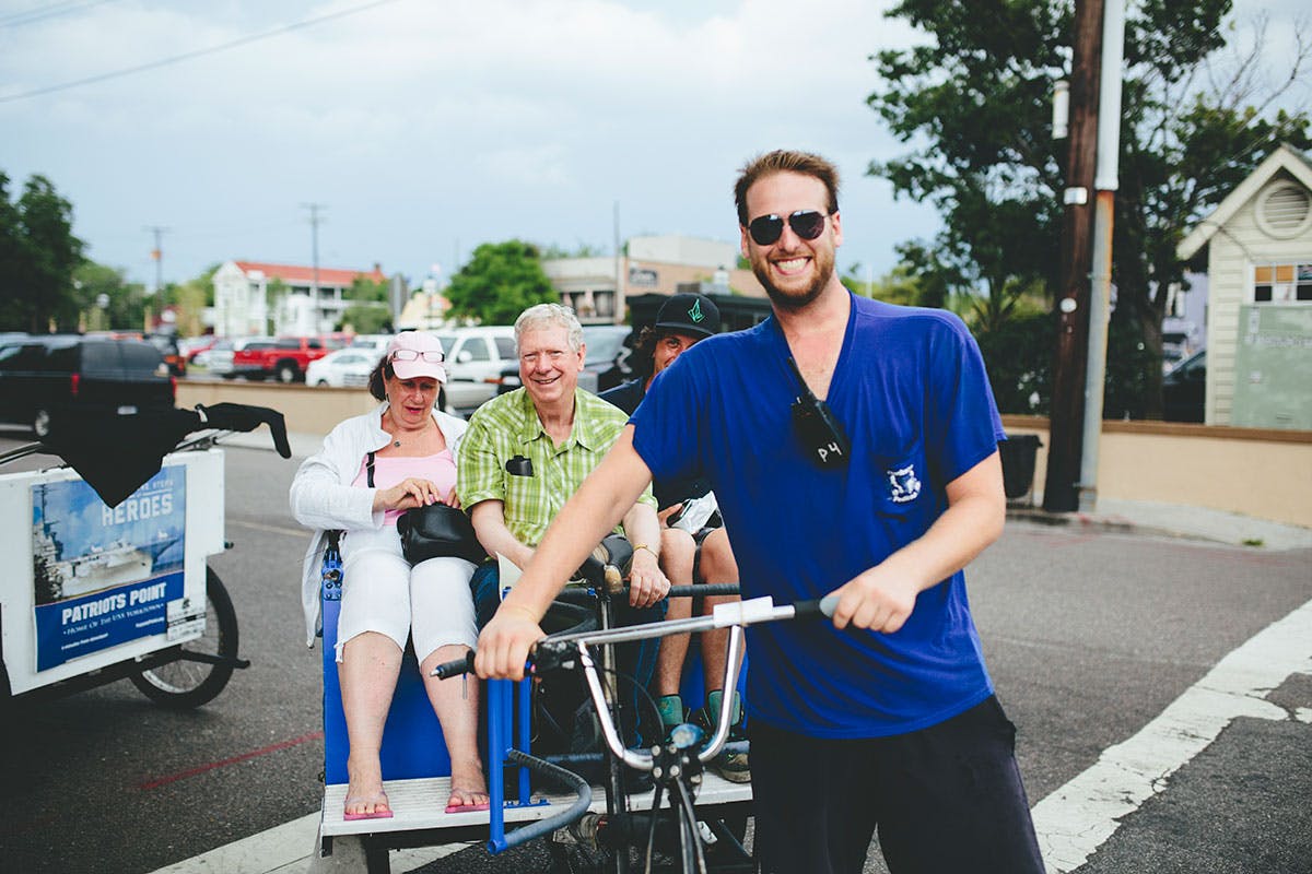 smiling-pedicab-driver-with-riders Pedicab driver and passengers smile at camera