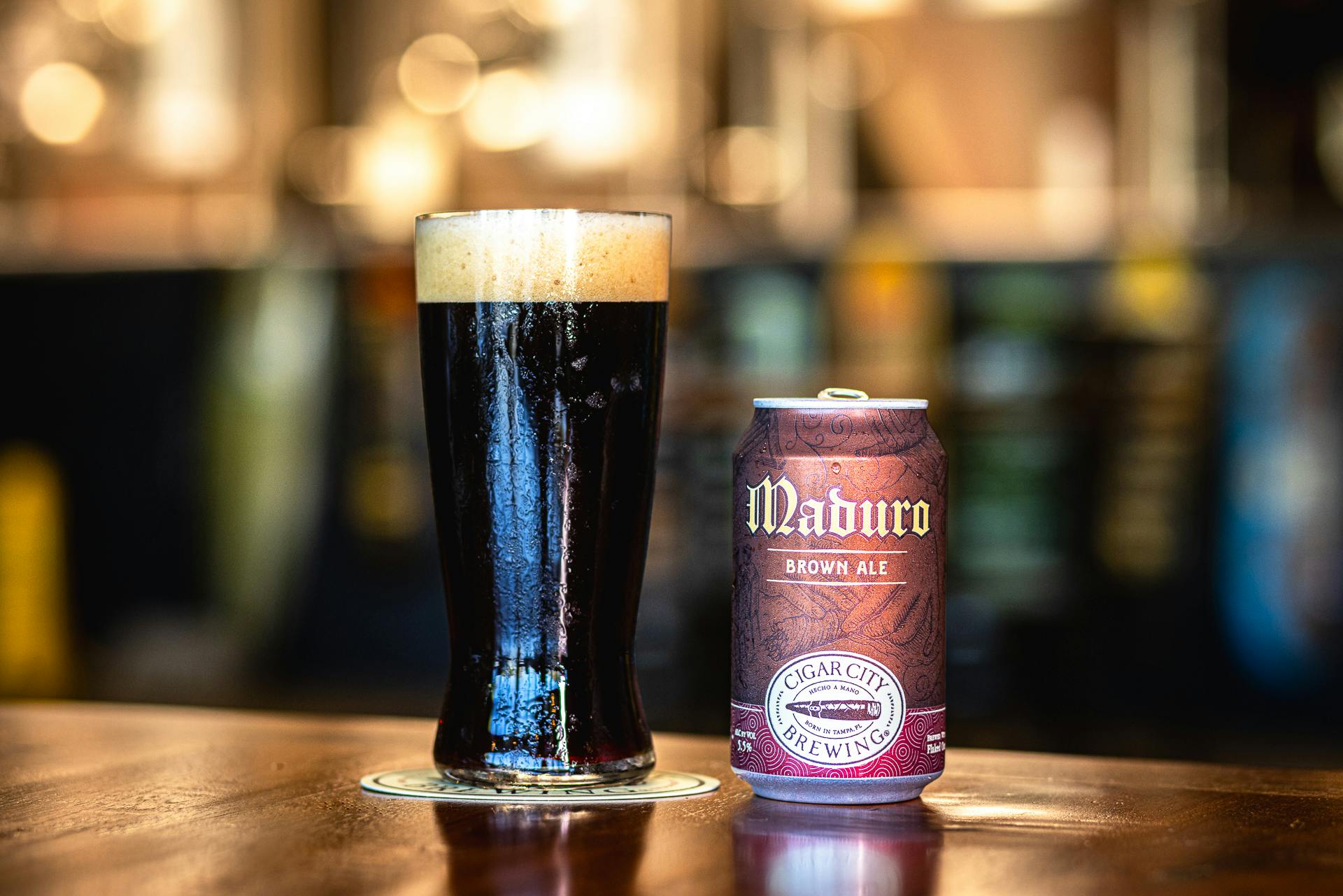 CCB_Website-44 Dark beer in a pin glass and a can of Maduro Brown Ale on a bar