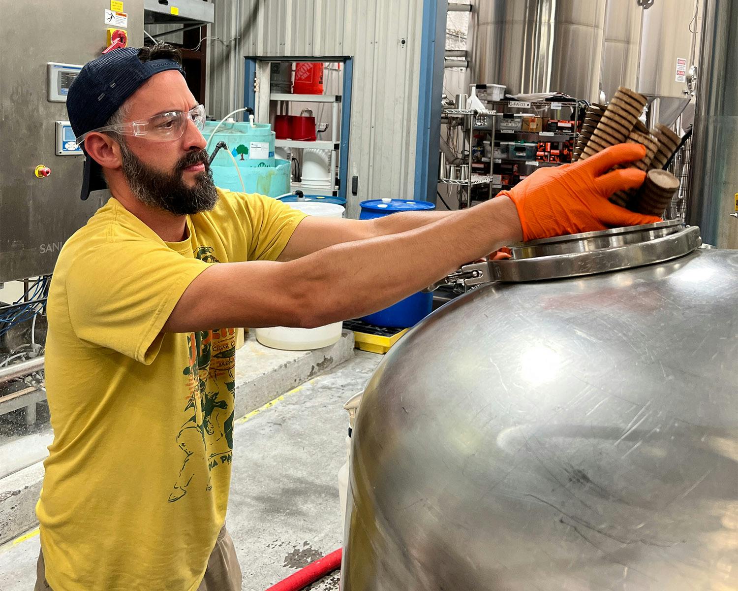 spinbot-web Brewer tests equipment in a stainless steel brewhouse