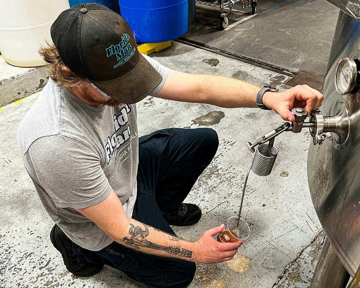 zwickel-web brewer pulls a sample of beer from a tank