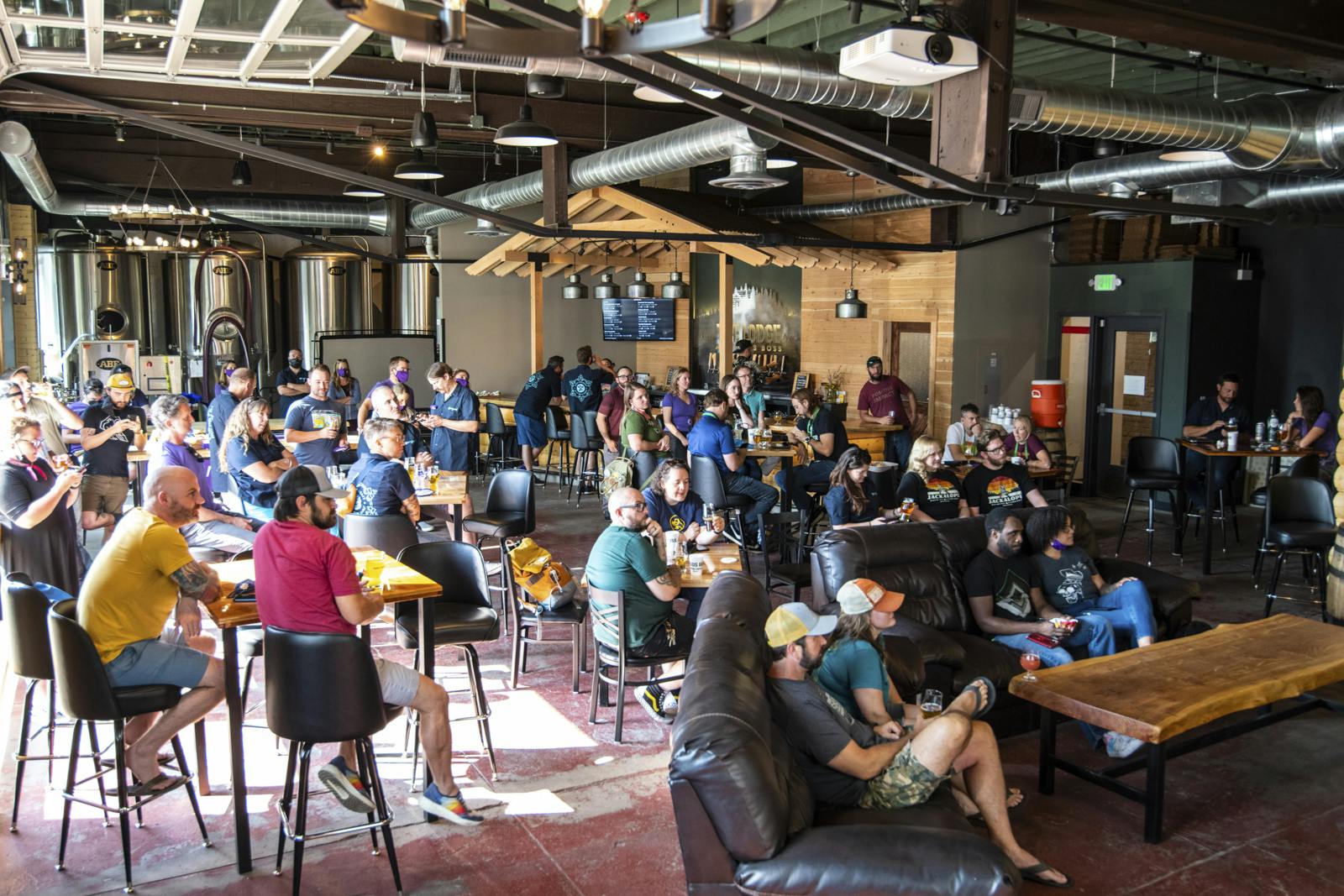a room of people at tables listening to a presentation
