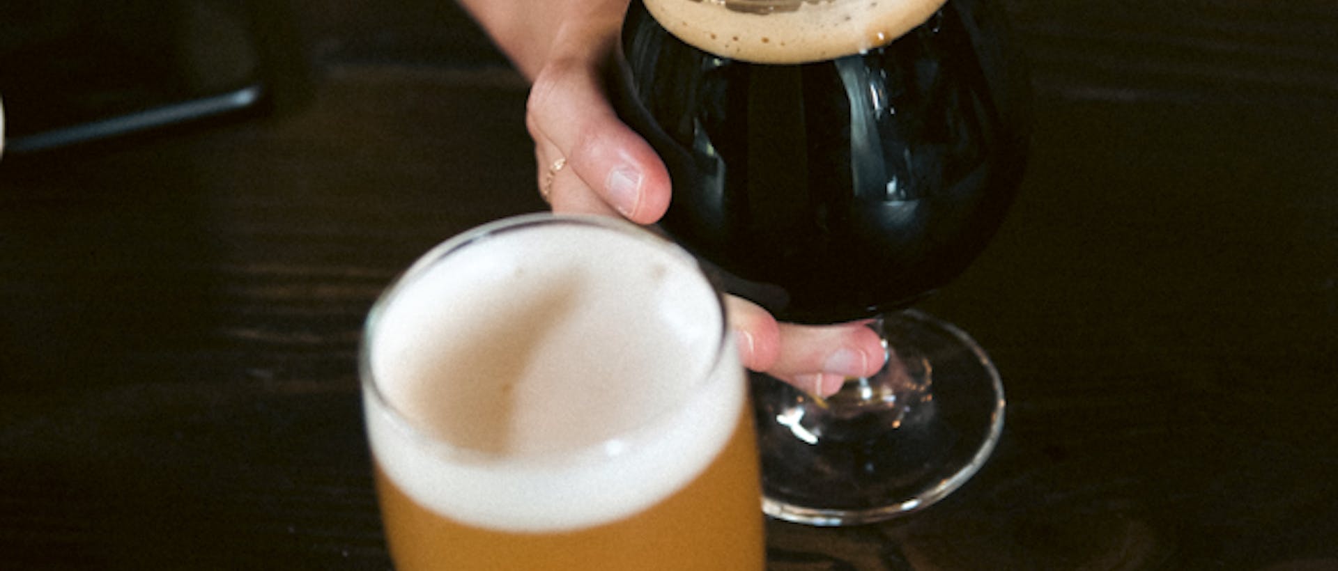 Two hands holding glasses of beer