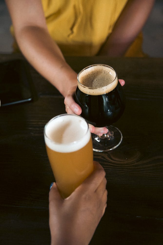 Two hands holding glasses of beer