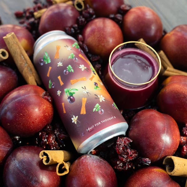 magenta beer with beer can surrounded by cherry and plums
