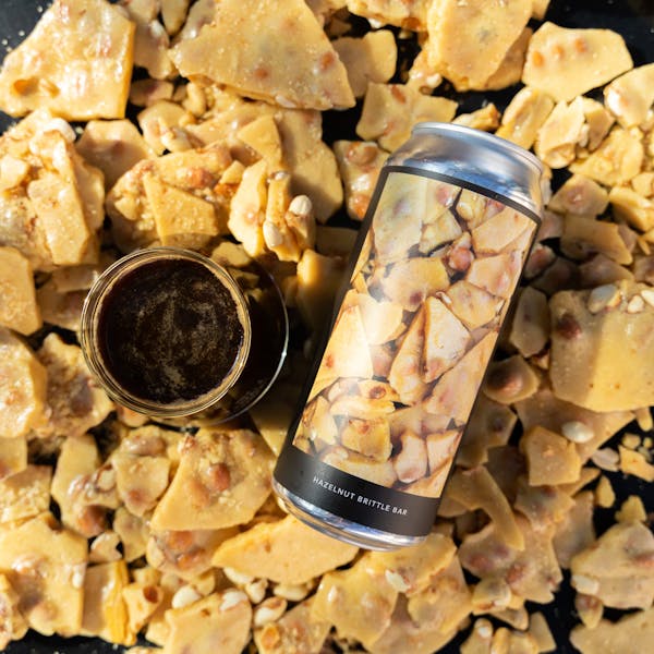 hazelnut brittle bar surrounding glass of stout and can
