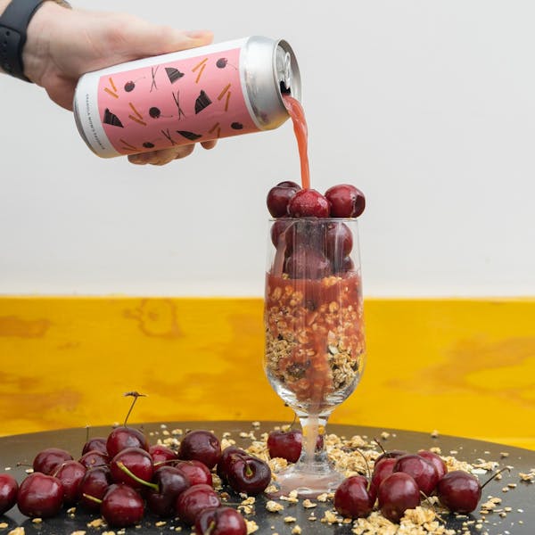 red sour beer pouring into glass of granola