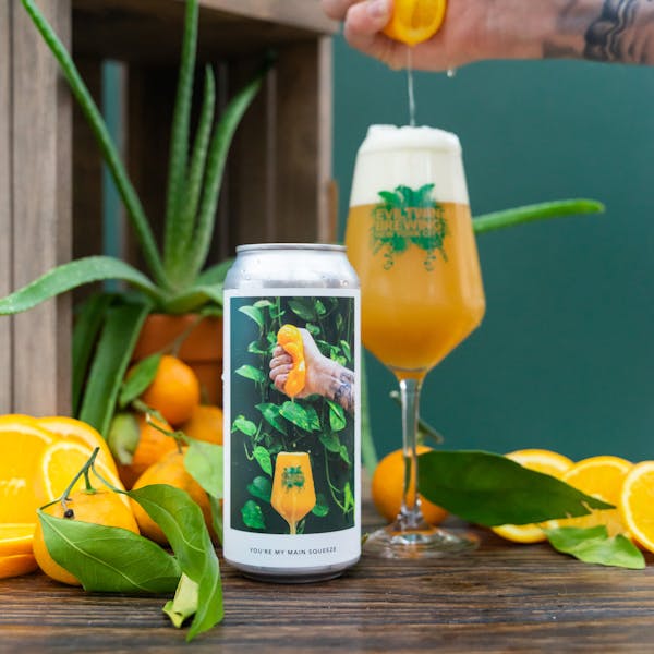 hazy pale ale with tangerines in background