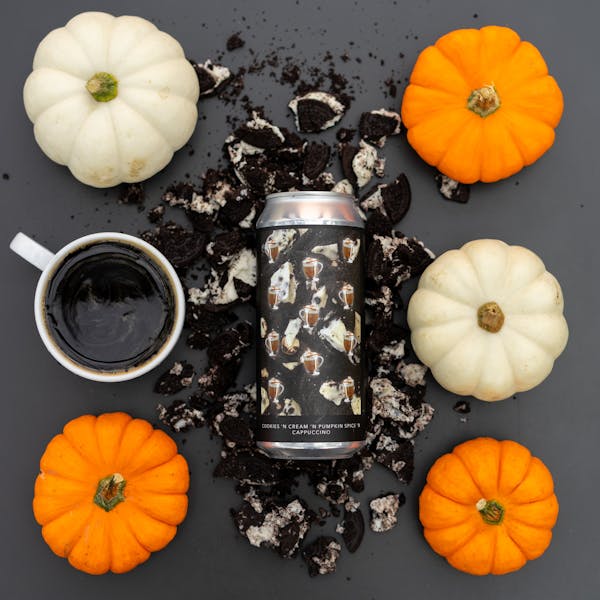 dark beer in glass on table with pumpkins