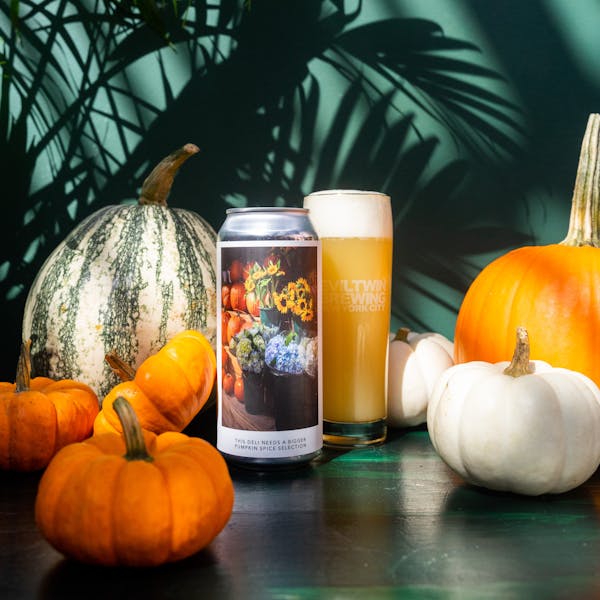 yellow beer in glass on table with pumpkins