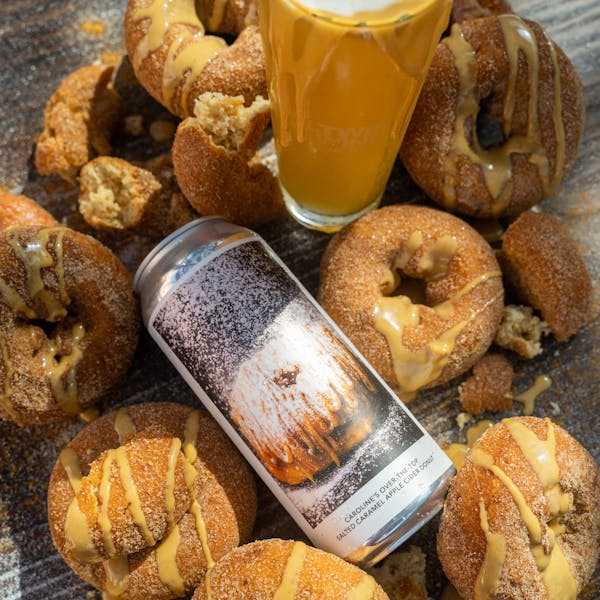 yellow beer in glass on table with donuts