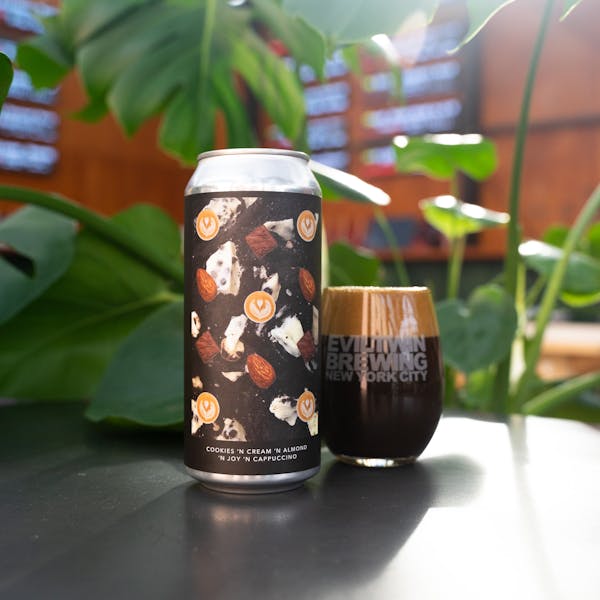 dark beer in glass with can on table