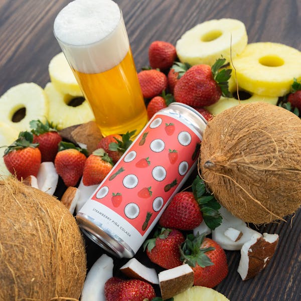 yellow beer in glass on table with can and fruits