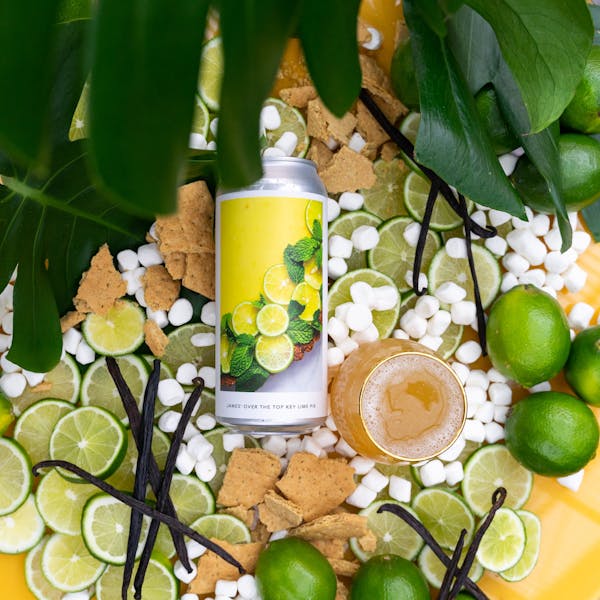 yellow beer in glass on table with fruits and plants