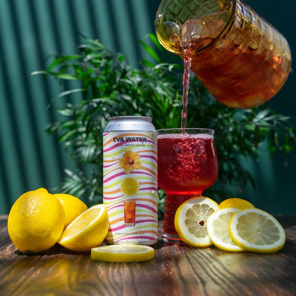 red seltzer in glass on table with lemons