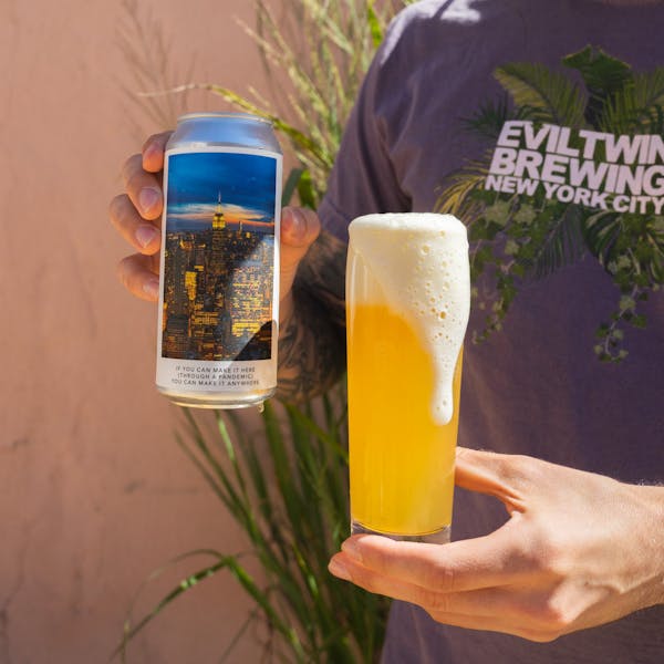 guy holding yellow beer in glass