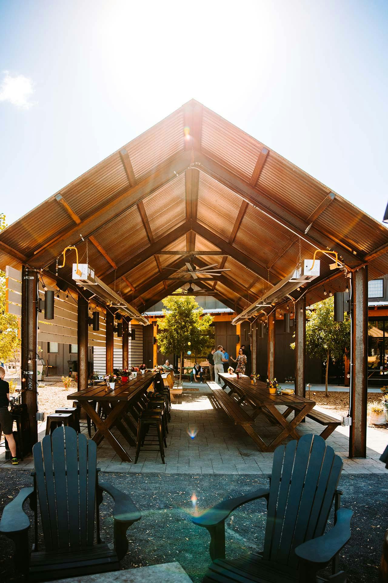 long tables outdoors under outdoor seating area roof