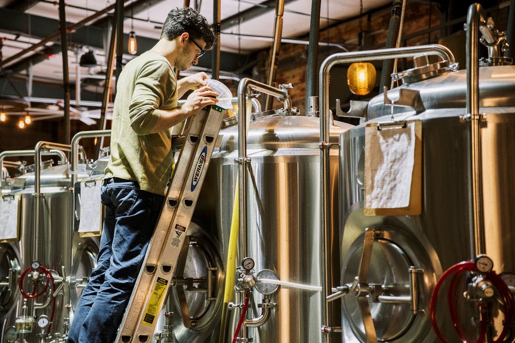 Vacmaster_Fireforge_56 copy 3 Brewer doing work with stainless steel brewing equipment