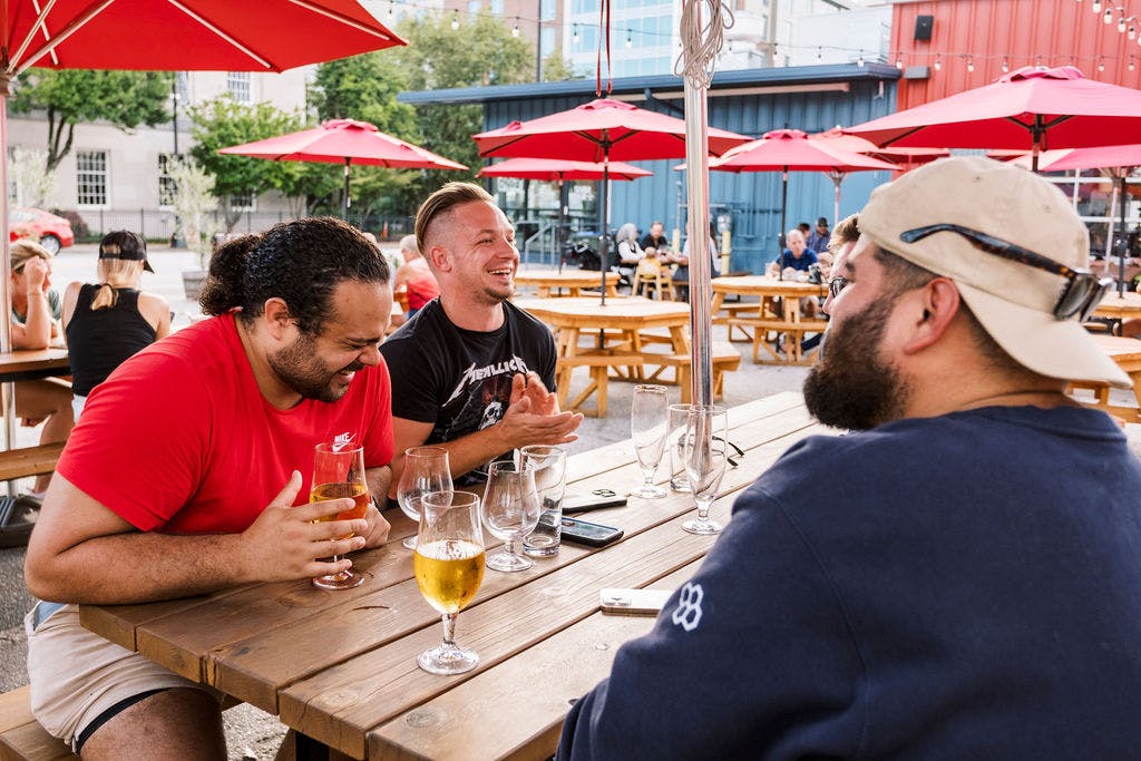 230929_Fireforge-976 guests enjoy beers at a table outside on the Fireforge taproom patio