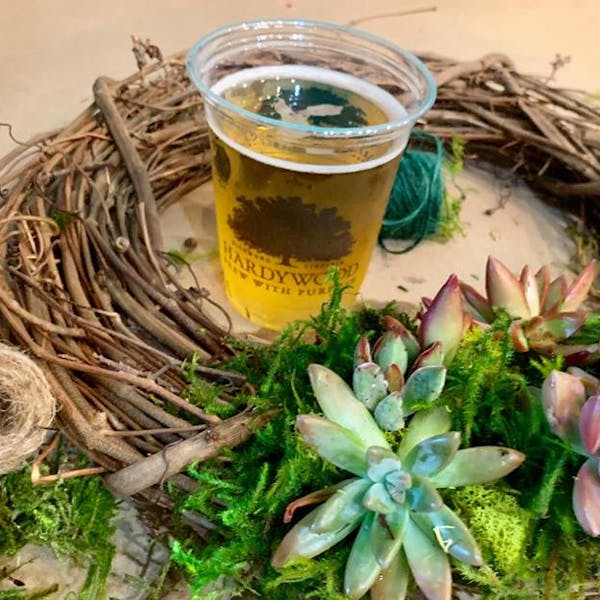spring wreath workshop photo with wreath and succulents and a beer