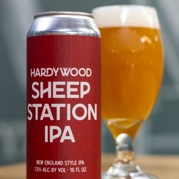 SheepStation 16oz Can of Sheep Station IPA with a full pour glass of Hazy beer next to it