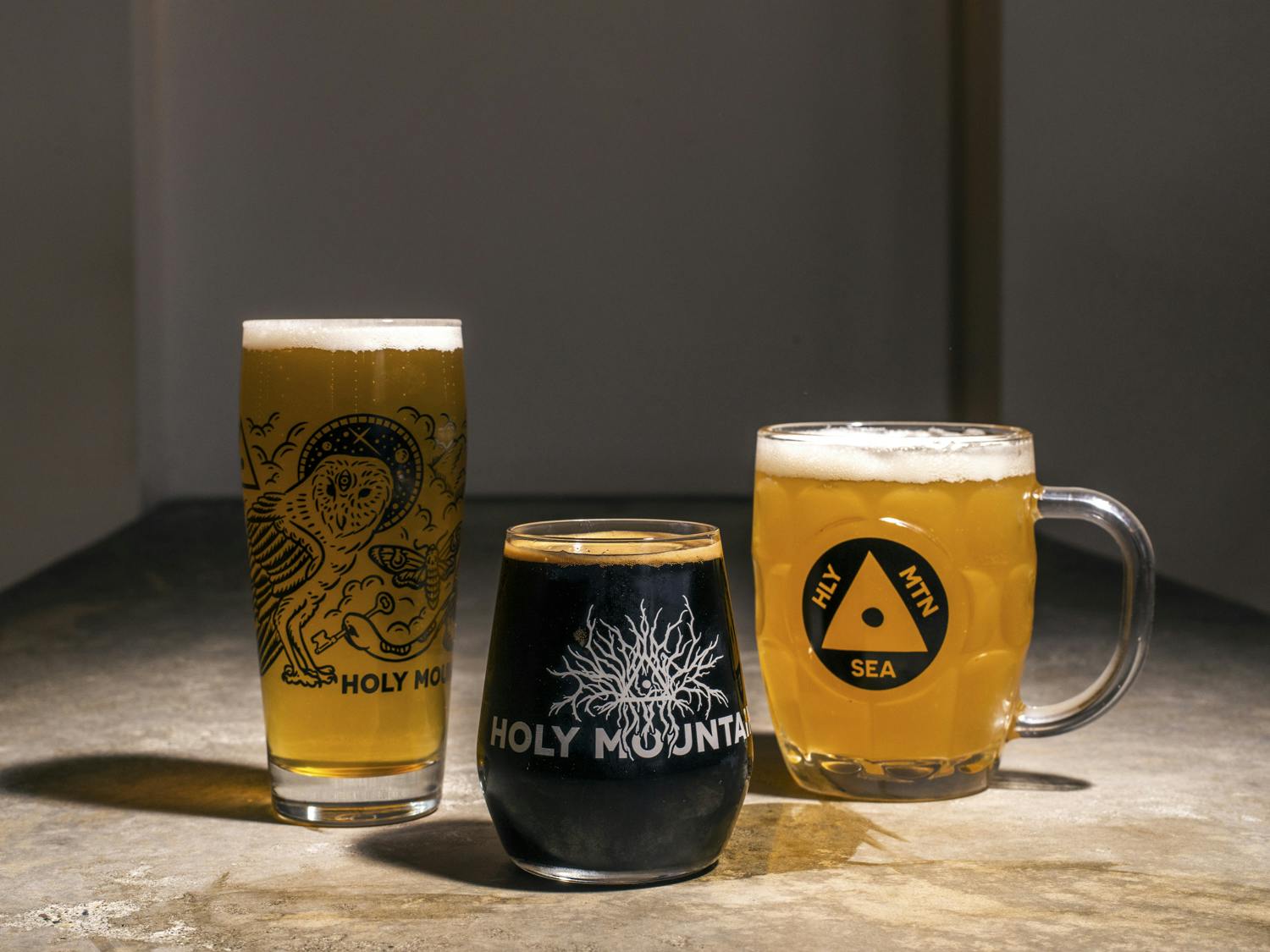 three beers on a table in the taproom in Holy Mountain glassware