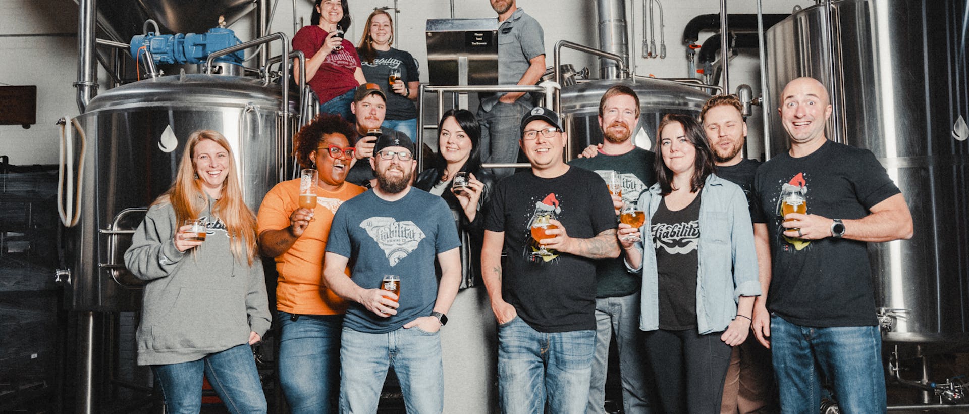 the staff in front of the brewing equipment