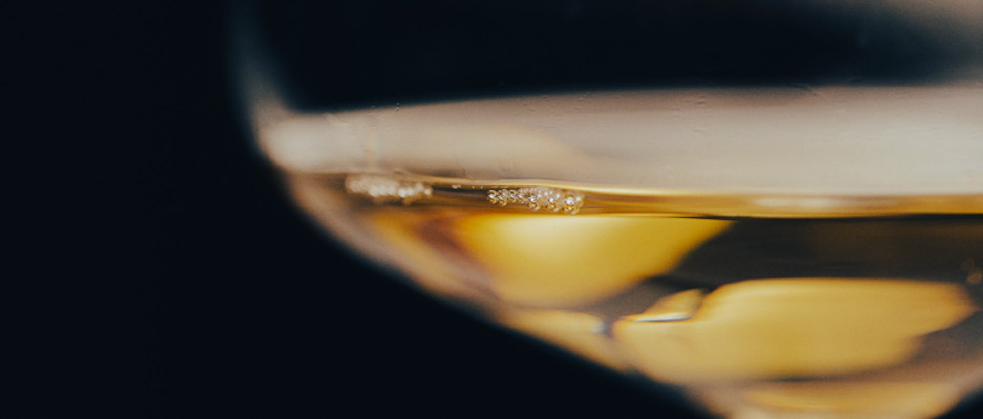 close-up of wine glass with a small amount of white wine in it