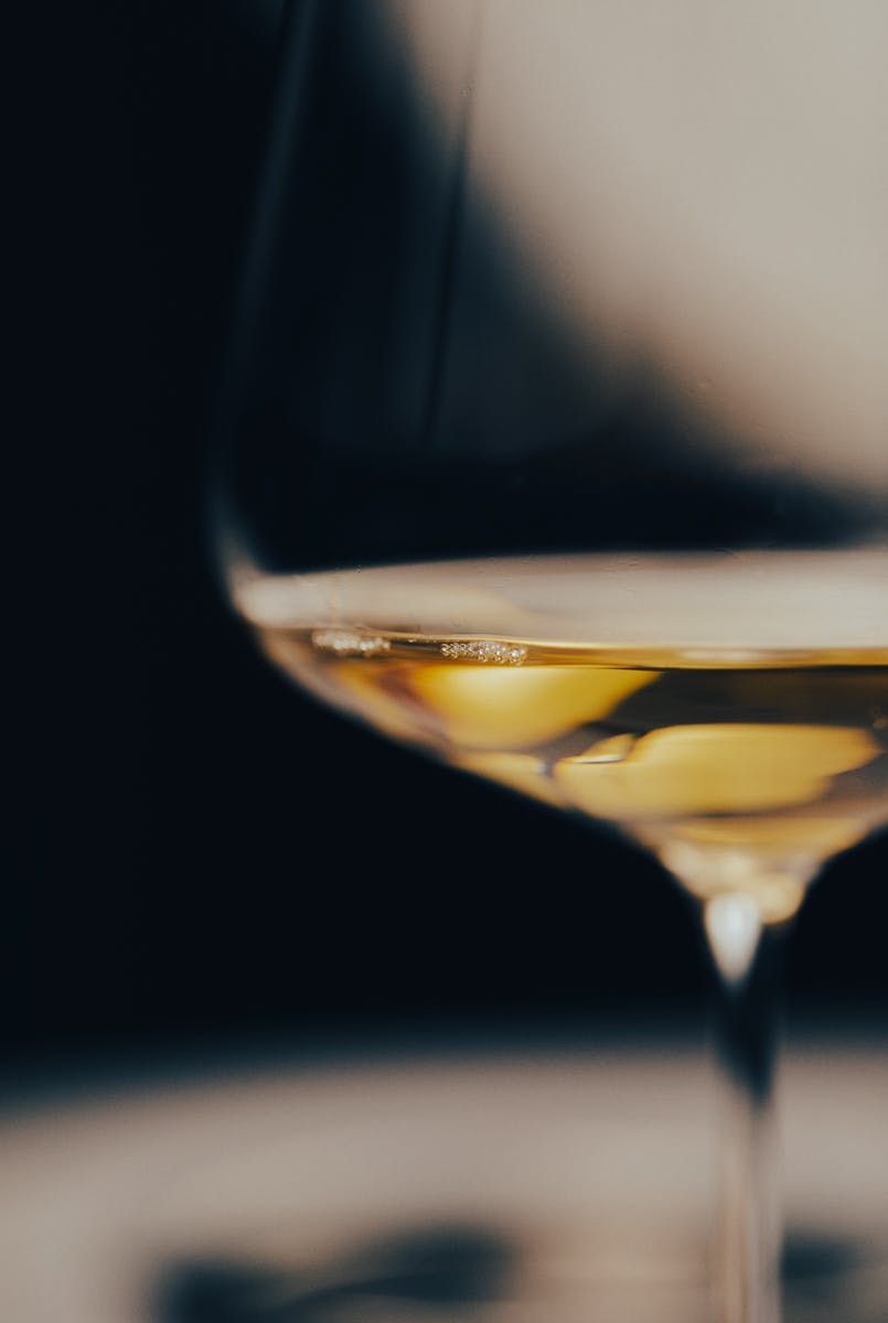 close-up of wine glass with a small amount of white wine in it