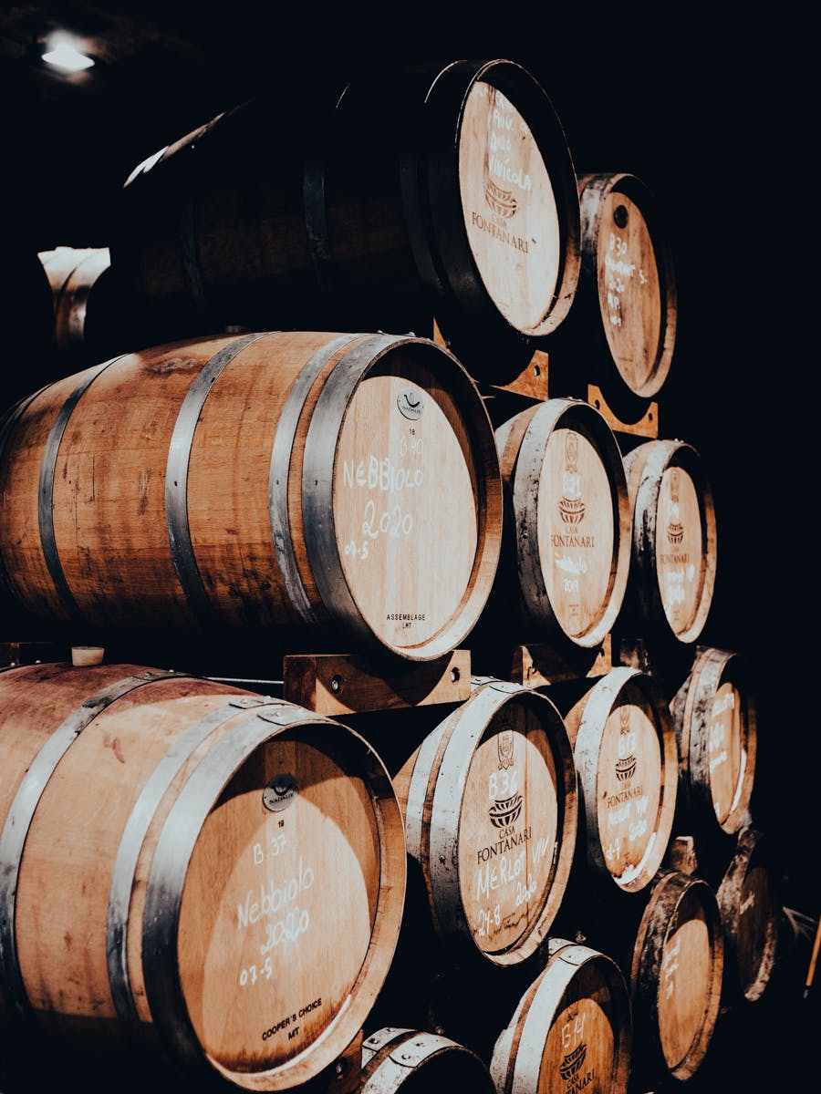 Stack of wine aging barrels in a cellar